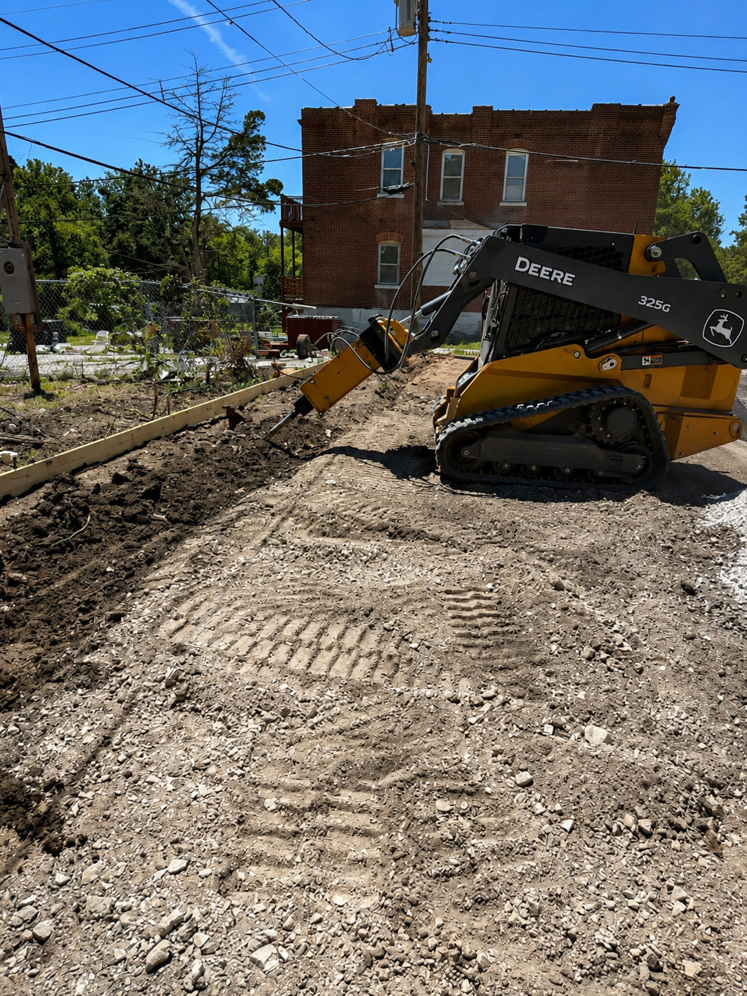True Form Concrete crew on a job site with skid steer prepping for a pour