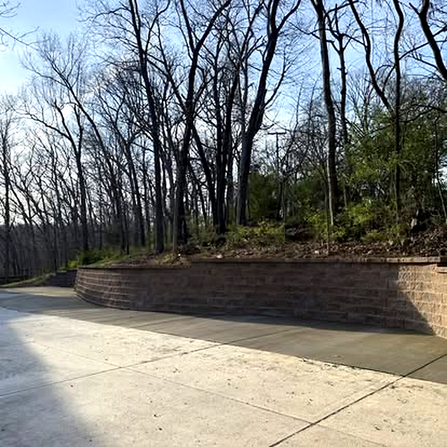 True Form Concrete retaining wall and driveway in wooded setting